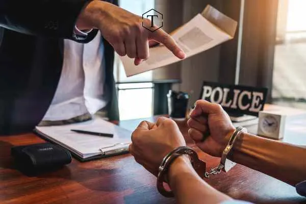 handcuffed person across from larceny defense attorney